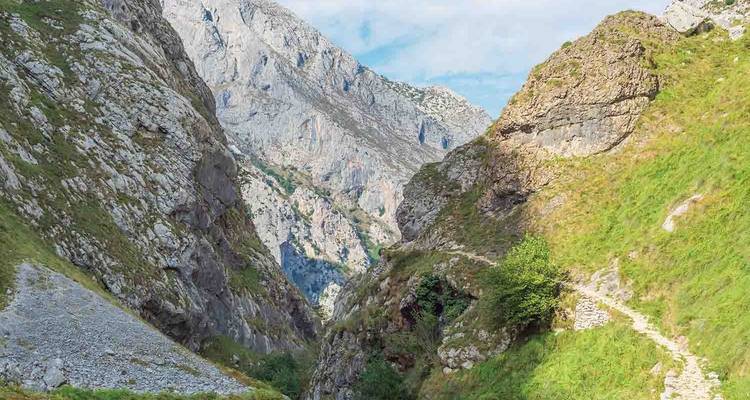 A steep rocky canyon with a walking trail.