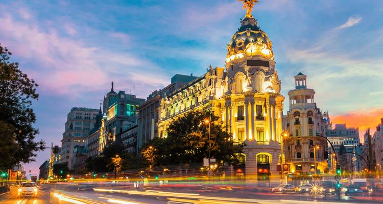 Le bâtiment Metropolis à Madrid au crépuscule avec des traînées de lumière.