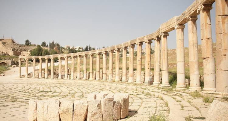 La extensa plaza ovalada con columnatas y pilares de la antigua Jerash se bañan en una luz suave.
