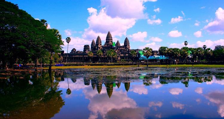 View of the historic Angkor Wat temple with reflections in water.