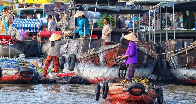 Bustling floating market with colorful boats and people selling goods.