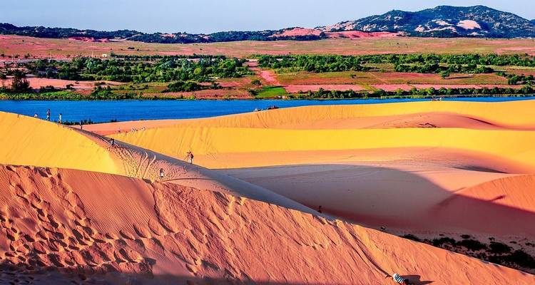 Colorful sand dunes under a bright blue sky in a picturesque landscape.