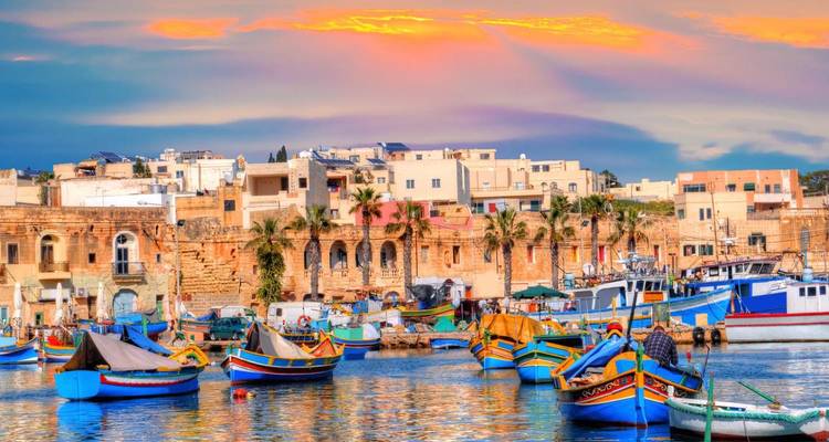 Une scène de port animée avec des bateaux maltais traditionnels.