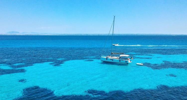 Zwei Segelboote auf klarem blauem Wasser.