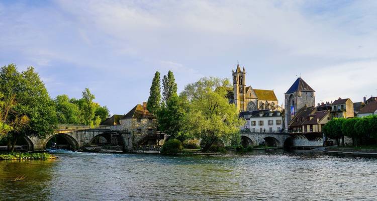 Historische Steinbrücke und Gebäude an einem Fluss.