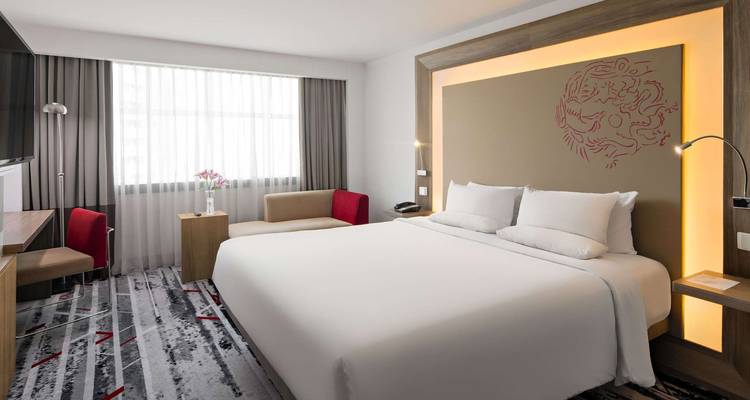 Chambre d'hôtel moderne avec un lit king-size et une décoration élégante.