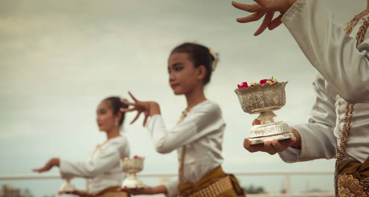 Jeunes danseurs cambodgiens en costume traditionnel effectuant une performance avec des bols d'offrande en argent