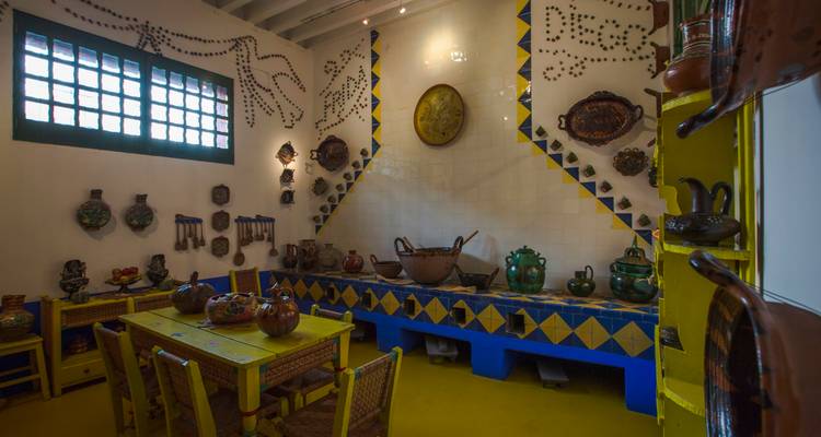 Farbenfrohe traditionelle Küche mit leuchtend gelber, blauer und grüner Einrichtung im Museum von Frida Kahlos Casa Azul