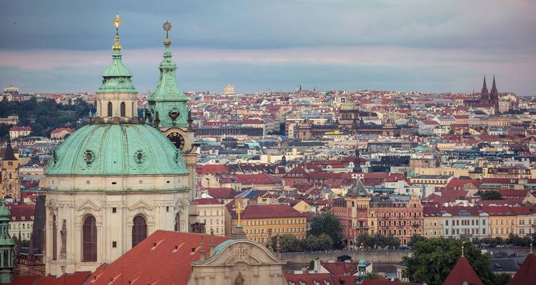 Los domos de cobre de la Iglesia de San Nicolás se elevan sobre un vasto panorama de los tejados rojos de Praga.