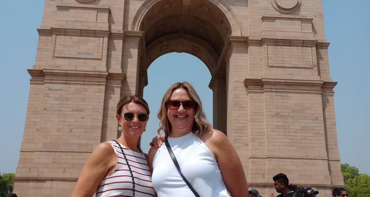 Dos personas posando frente al monumento histórico del arco.