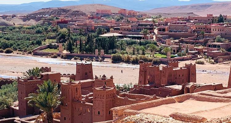 Historische Lehmgebäude umgeben von üppigem Grün.