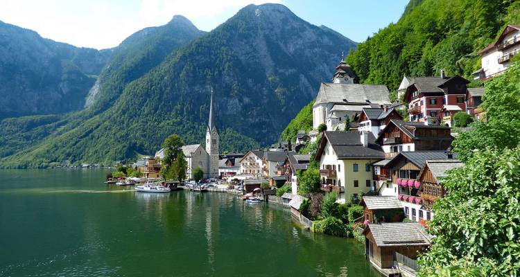 Scenic town by the lake with mountains in the background.