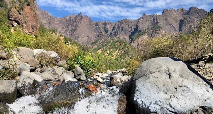 Mountain landscape with a stream flowing in the foreground.