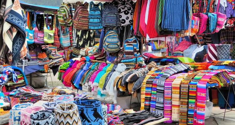Colorful display of textiles and crafts at an outdoor market.