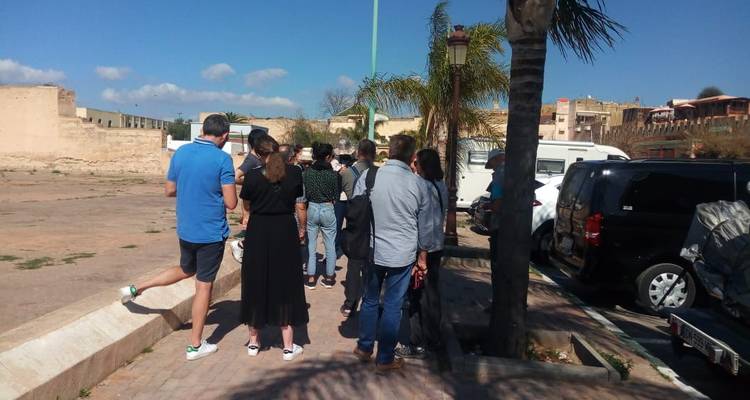 Gruppe von Menschen in einer Schlange in der Nähe eines historischen Gebäudes.