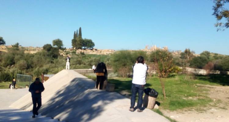 Verschwommenes Bild von Menschen auf einem Gehweg in einem grünen Bereich.