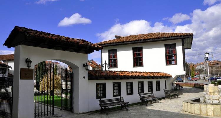 Patio de piedra y casa tradicional con entrada arqueada.