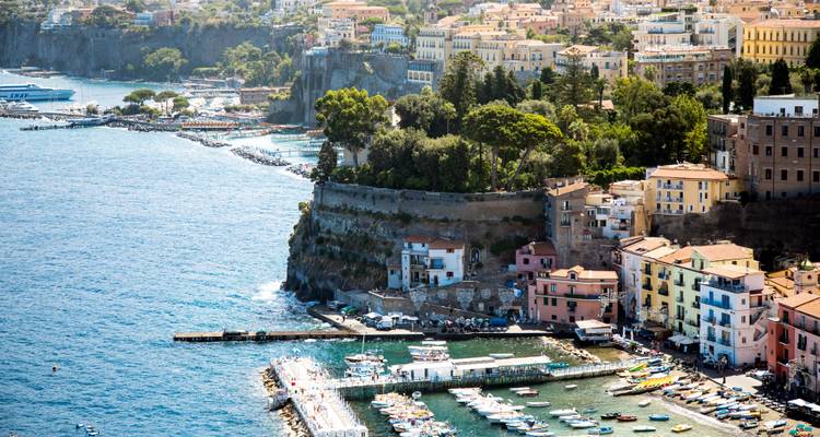 Edificios coloridos en la ladera y marina de Sorrento con vistas al mar azul profundo.