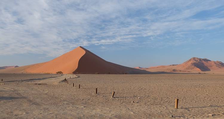 Paysage désertique avec une dune proéminente et un ciel bleu.