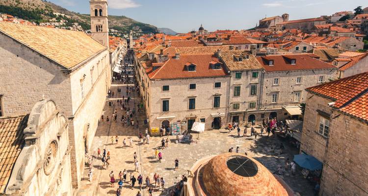 Pedestrian street in a historic city with stone buildings and visitors.