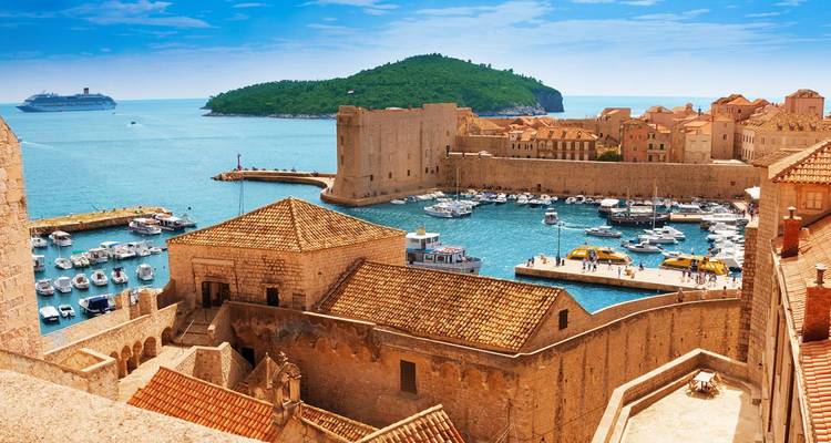 Dubrovniks Stadtmauern und Hafen mit Booten.