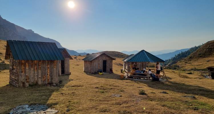 Hütten auf einer Ebene mit Menschen, die den Sonnenuntergang genießen.