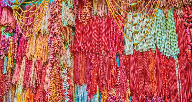Brightly colored bead necklaces hanging in a market.