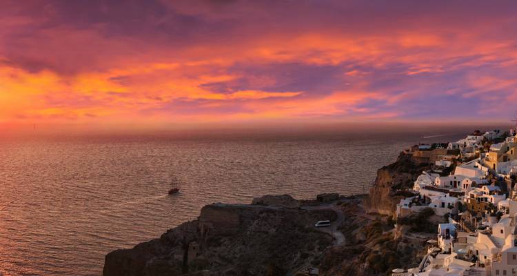 Sunset view over the sea with a cliffside village.