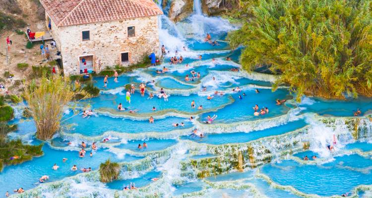 Des gens profitant de bains thermaux en cascade.