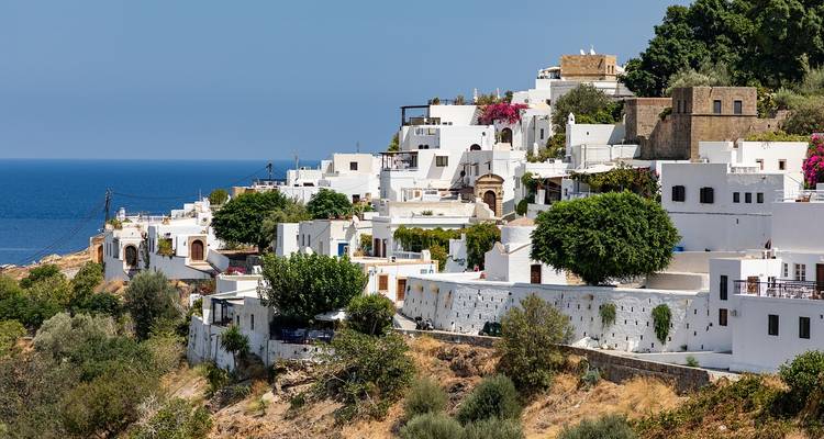 Whitewashed hillside village of Lindos cascading toward the Aegean Sea with splashes of bougainvillea.