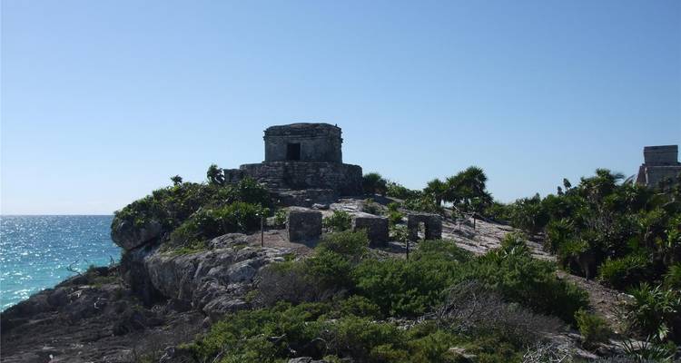 Petite ruine maya perchée sur une falaise rocheuse surplombant la mer des Caraïbes turquoise