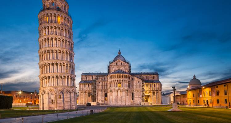Torre Inclinada de Pisa y catedral adyacente al atardecer.