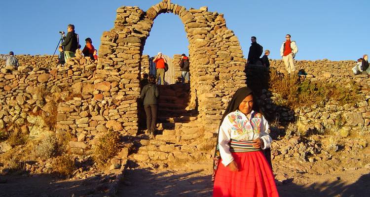 Steinbogen mit Menschen in traditioneller Kleidung, die gehen.