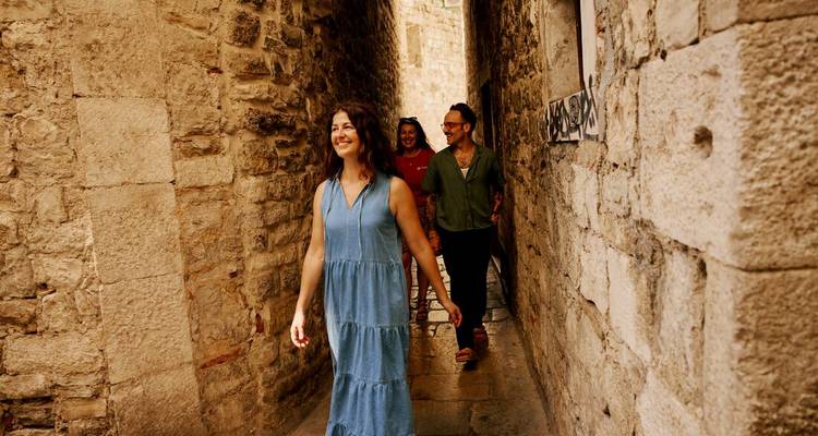 Des amis se promenant dans une ruelle pavée étroite d'une vieille ville croate.