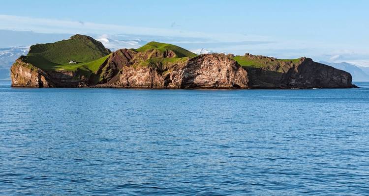Island with green grass and rocky edges