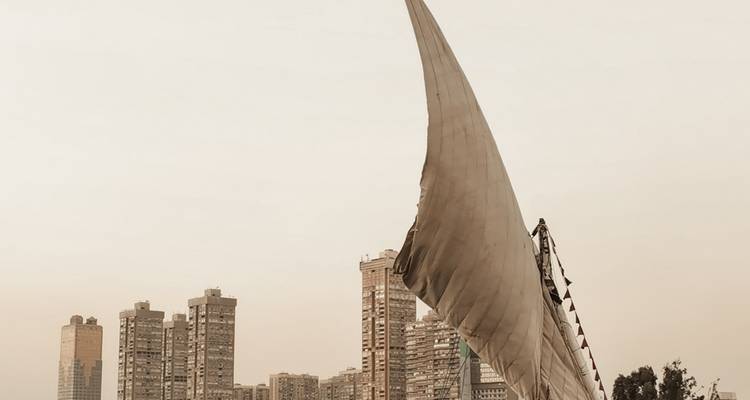 Segelboot mit Stadtbild und Wolkenkratzern im Hintergrund.