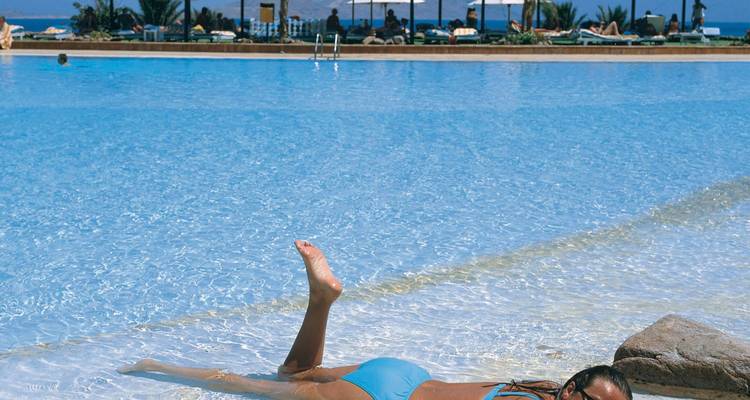 Person, die in einem Schwimmbad ein Sonnenbad nimmt.