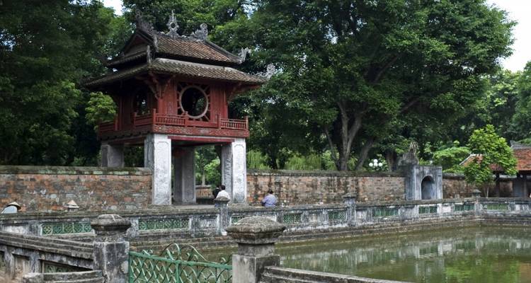 Oude tempel met traditionele architectuur en mensen die op bezoek zijn.
