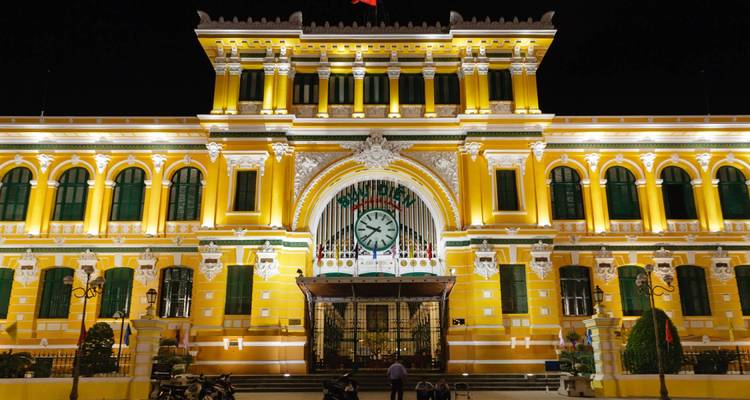 Het helder verlichte Centrale Postkantoor van Saigon 's nachts in Ho Chi Minh-stad.