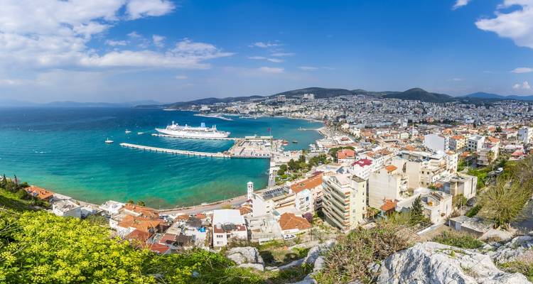 Vista aérea de una ciudad costera con un puerto y cruceros.