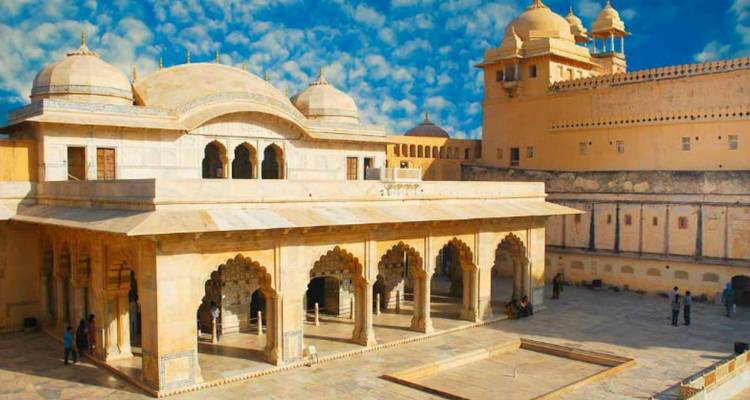 Historische Architektur mit einem offenen Innenhof unter einem hellen Himmel.