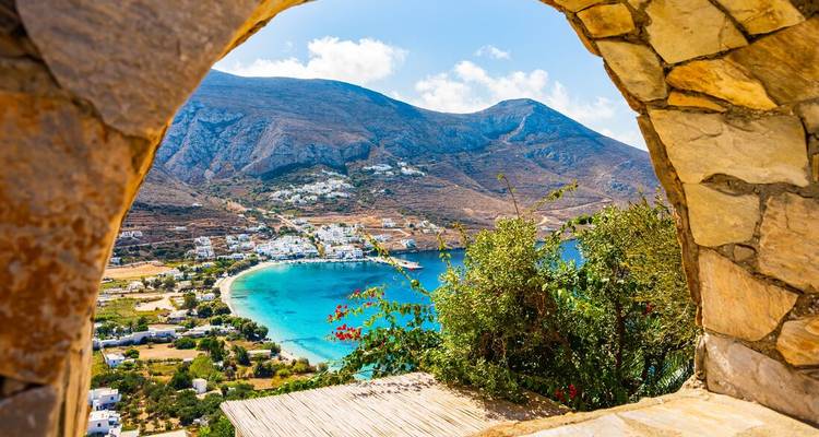 Une vue panoramique à travers une arche donnant sur une baie turquoise.