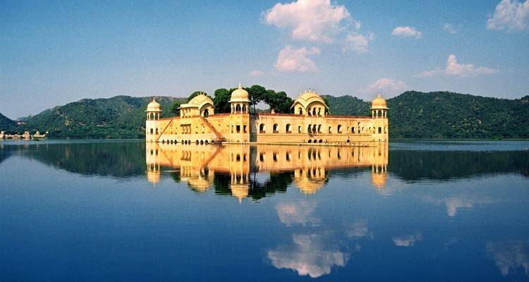 Jal Mahal palace in the middle of a lake with a reflection.