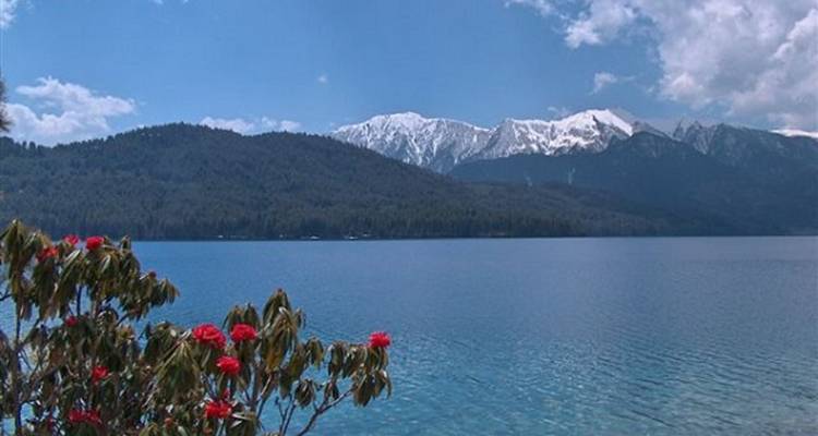 See mit verschneiten Bergen im Hintergrund