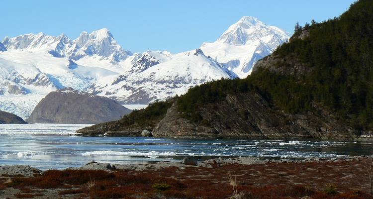 Berge und Gletscher spiegeln sich in einem See.