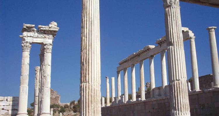 Ruinen einer antiken Stadt mit hohen Marmorsäulen vor einem blauen Himmel.