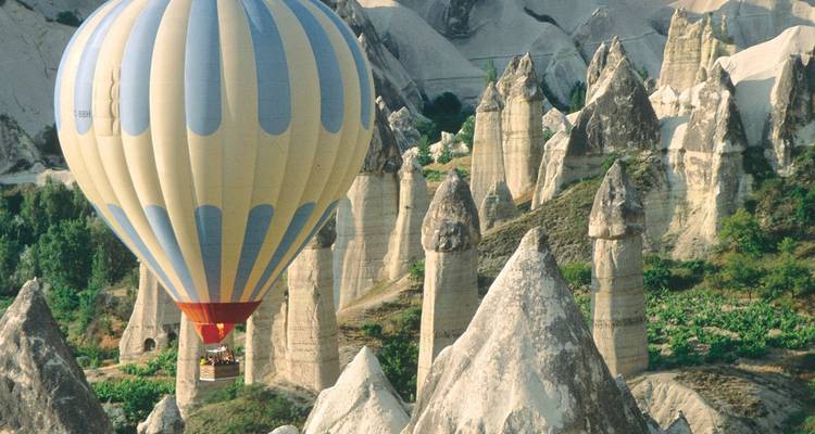 Heißluftballon fliegt über einzigartige Felsformationen.