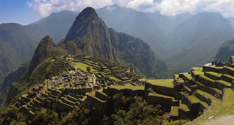 Machu Picchu stadsgezicht met iconische bergen onder een dramatische hemel.