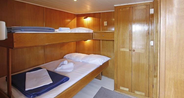 Houten hut met stapelbedden op een boot.