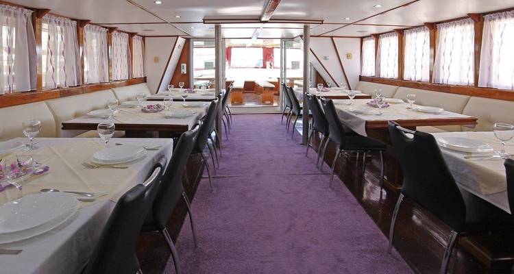 Eetruimte op een boot met tafels gedekt voor maaltijdservice.